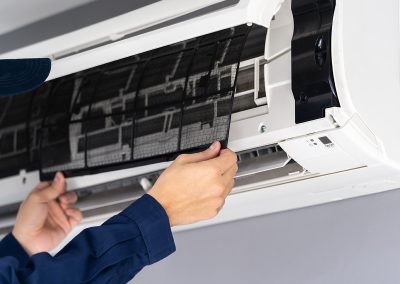 Uma pessoa a retirar o filtro de aparelho de ar condicionado