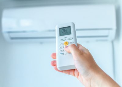 Pormenor de uma mão a usar o comando de um aparelho de ar condicionado